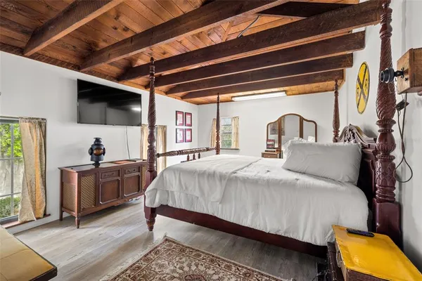 a bedroom with bed and wooden floor