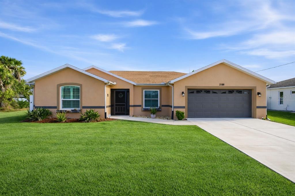 2198 Hopwood Road North Port, FL 34287 - Photo 1 of 1 a front view of a house with a garden and yard