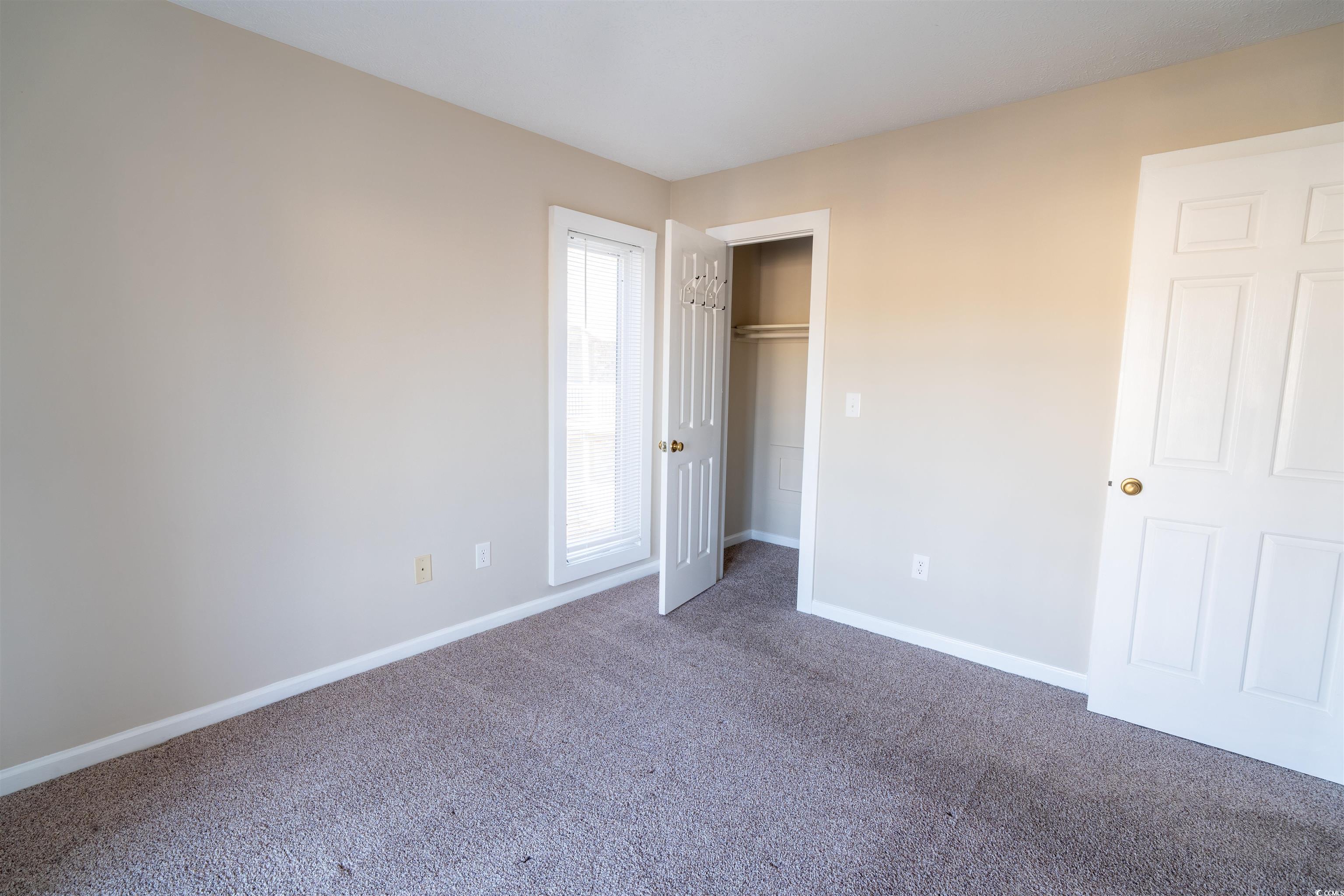 4708 Cobblestone Drive, Unit I8 Myrtle Beach, SC 29577 - Photo 10 of 15 Unfurnished bedroom featuring carpet flooring and a closet