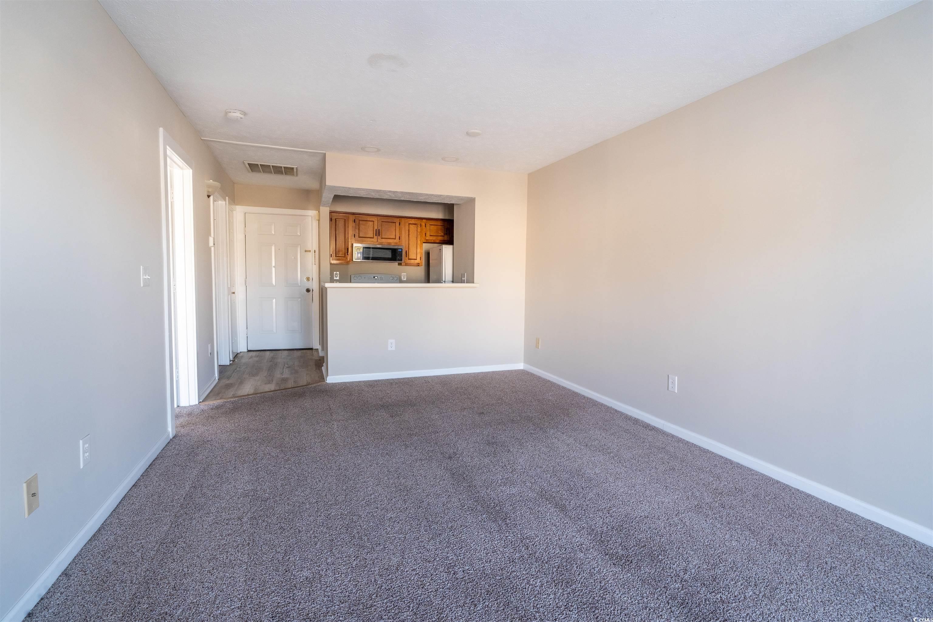 4708 Cobblestone Drive, Unit I8 Myrtle Beach, SC 29577 - Photo 6 of 15 Spare room featuring dark carpet and baseboards