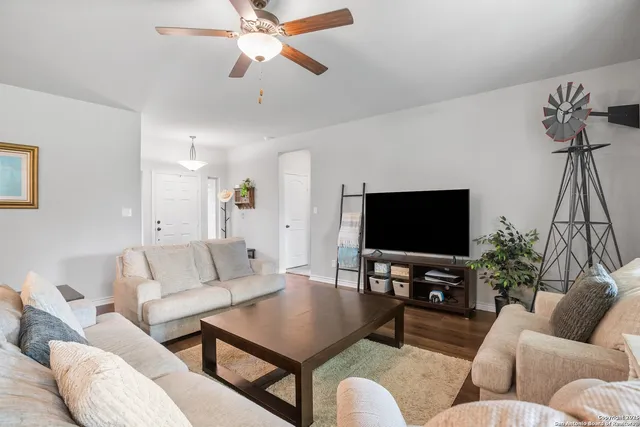 a living room with furniture kitchen and a chandelier