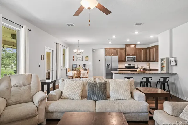 a view of a dining room with furniture a chandelier and wooden floor