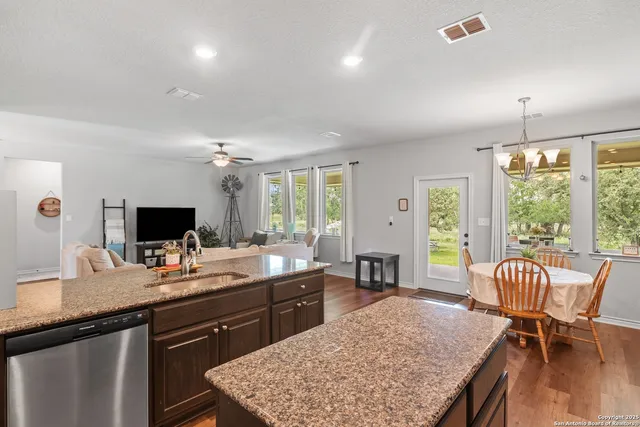a kitchen with stainless steel appliances granite countertop a refrigerator a stove and a sink