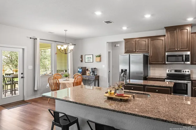 a kitchen with granite countertop a stove and a refrigerator