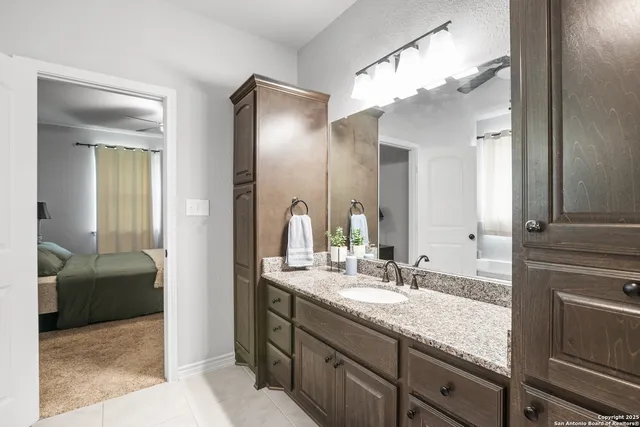 a bathroom with a granite countertop sink toilet and a mirror
