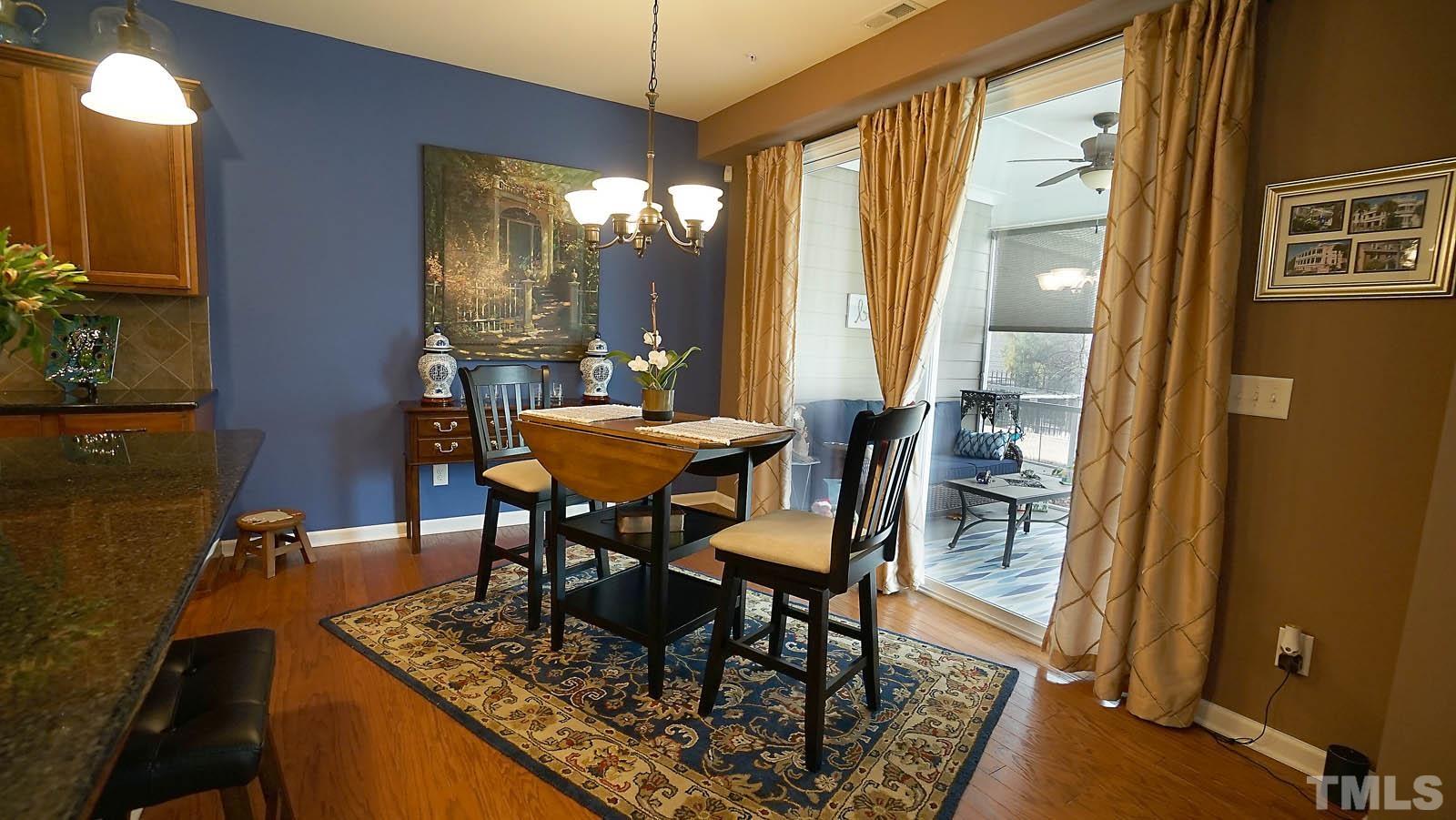 10115 Barnhart Way Raleigh, NC 27617 - Photo 13 of 60 a dining room with furniture a chandelier and wooden floor