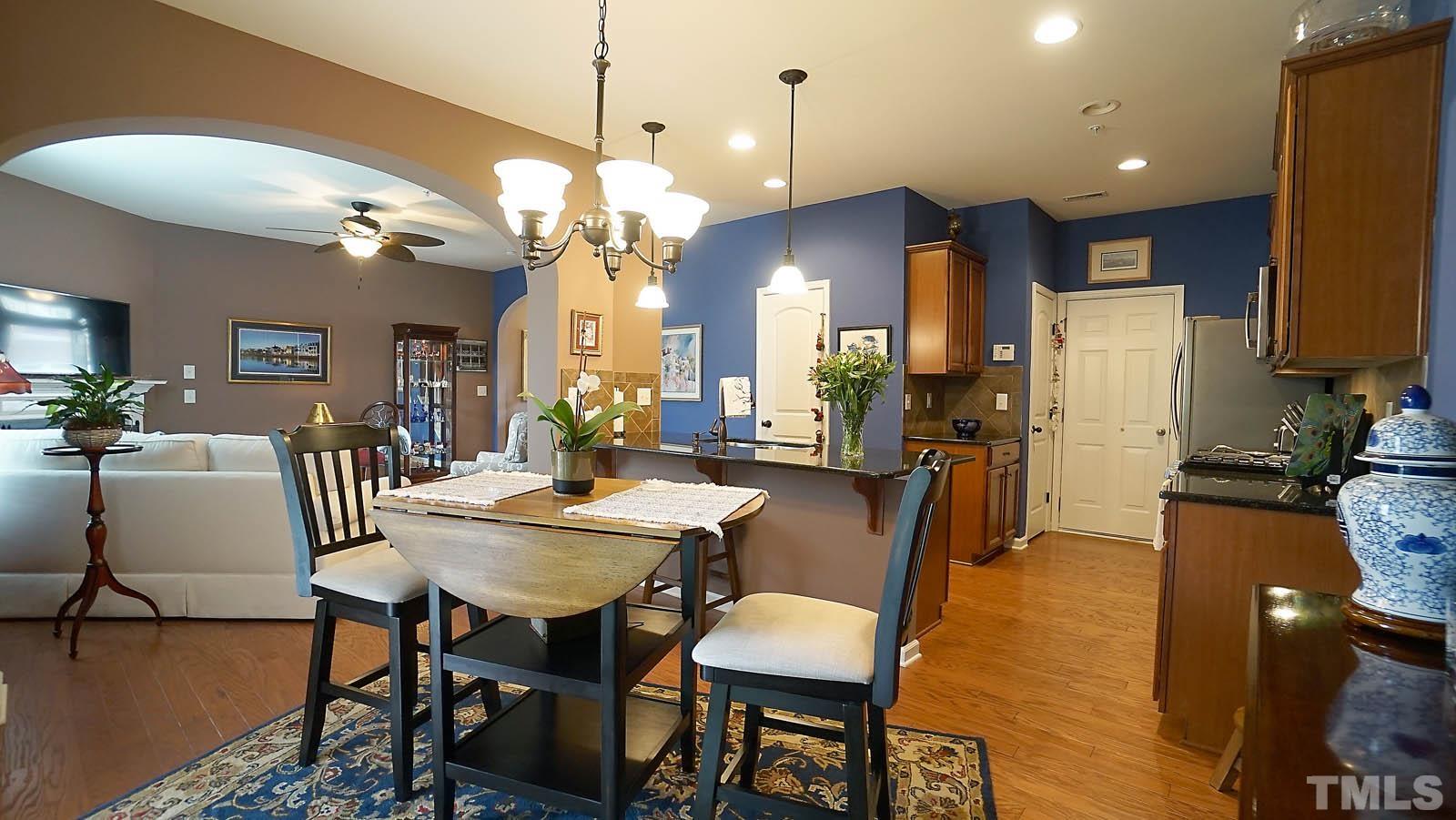 10115 Barnhart Way Raleigh, NC 27617 - Photo 16 of 60 a view of a dining room and livingroom with furniture wooden floor a chandelier