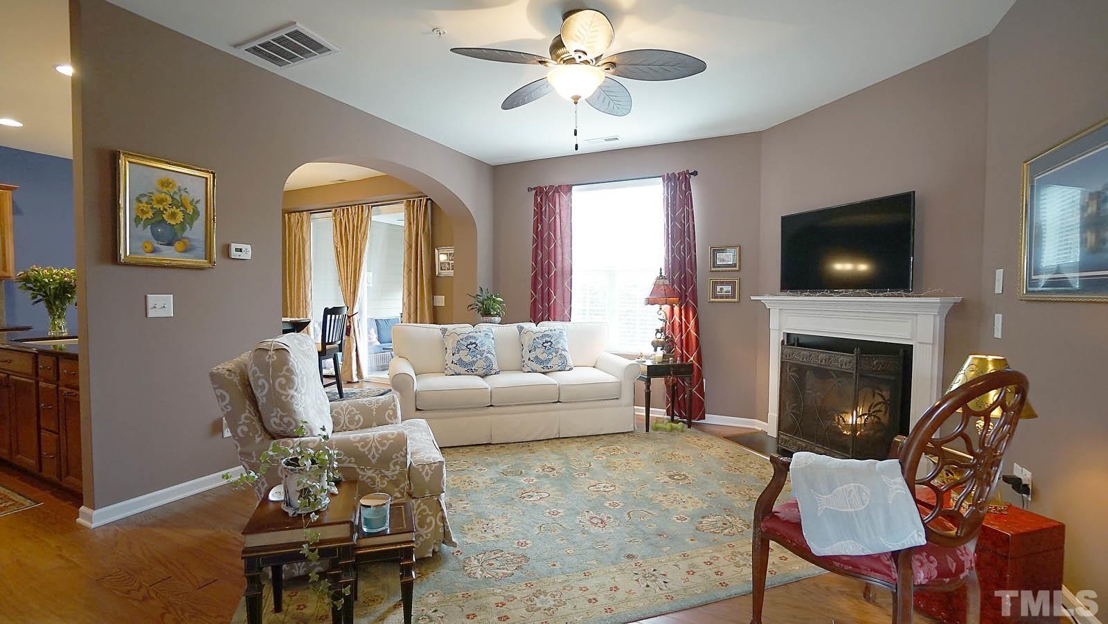10115 Barnhart Way Raleigh, NC 27617 - Photo 2 of 60 a living room with furniture a fireplace and a flat screen tv