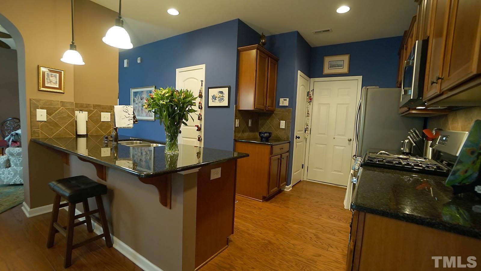 10115 Barnhart Way Raleigh, NC 27617 - Photo 21 of 60 a kitchen with stainless steel appliances granite countertop sink stove and cabinets