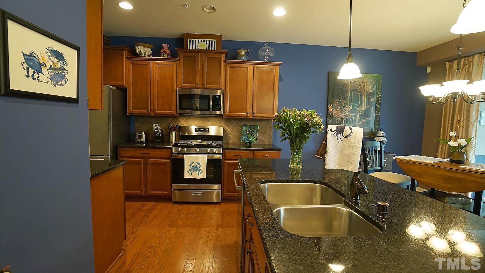 10115 Barnhart Way Raleigh, NC 27617 - Photo 23 of 60 a kitchen with counter top space cabinets and stainless steel appliances
