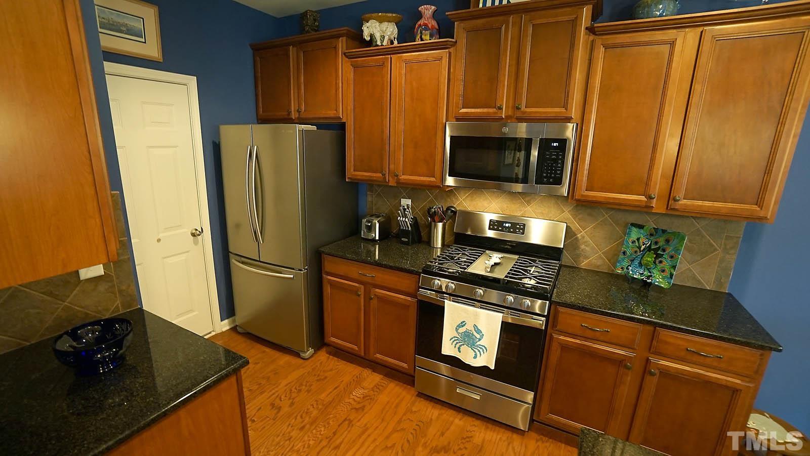 10115 Barnhart Way Raleigh, NC 27617 - Photo 25 of 60 a kitchen with stainless steel appliances granite countertop a refrigerator and a stove