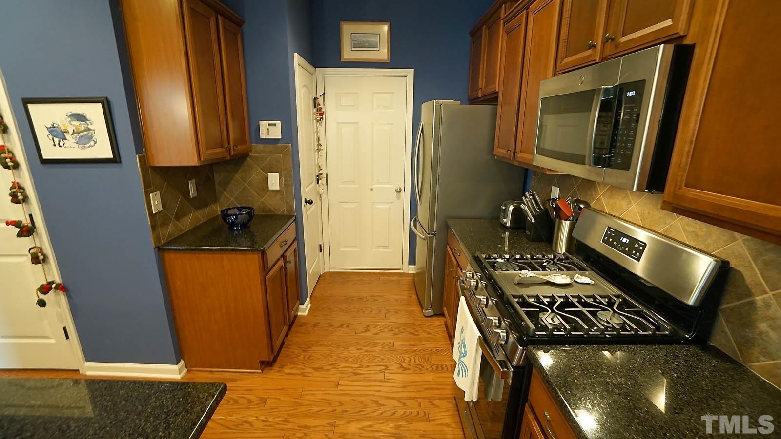 10115 Barnhart Way Raleigh, NC 27617 - Photo 26 of 60 a kitchen with stainless steel appliances granite countertop a stove a refrigerator and a microwave