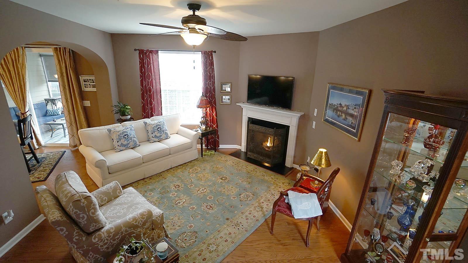 10115 Barnhart Way Raleigh, NC 27617 - Photo 3 of 60 a living room with furniture a flat screen tv and a fireplace