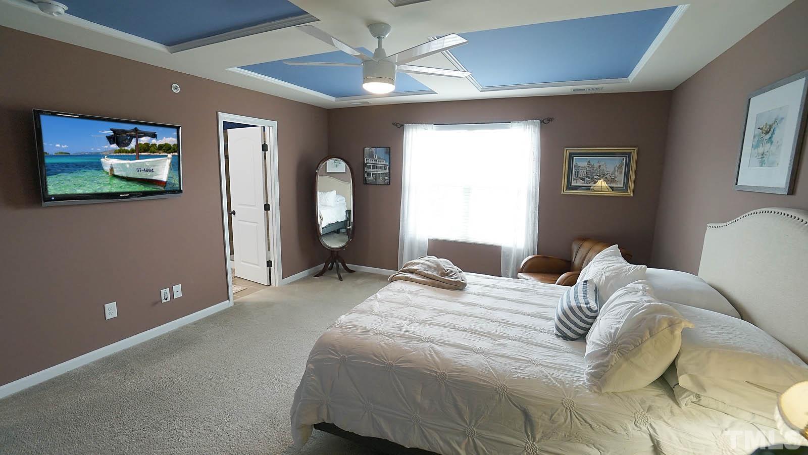 10115 Barnhart Way Raleigh, NC 27617 - Photo 41 of 60 a bedroom with a bed and a painting on the wall