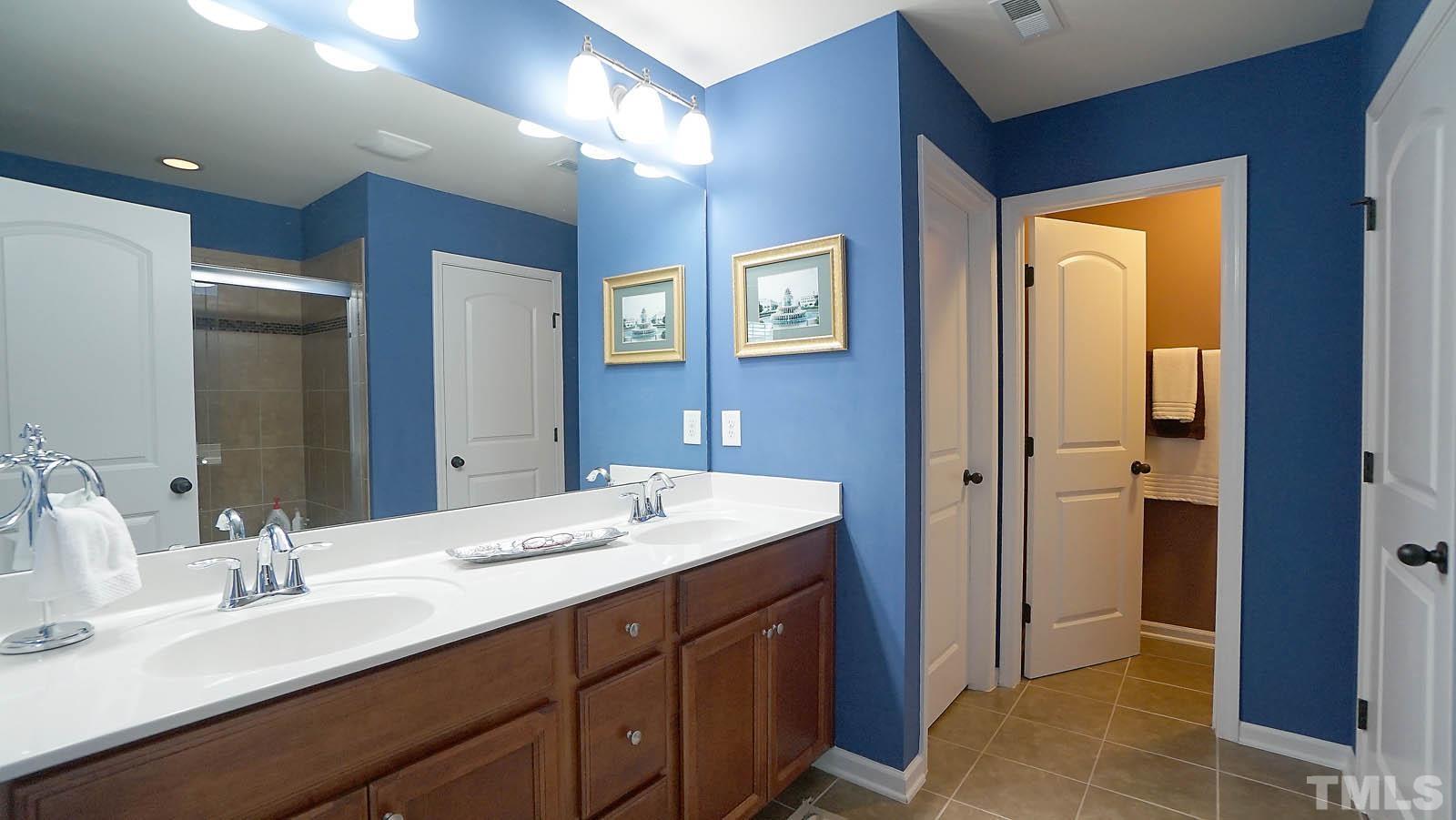 10115 Barnhart Way Raleigh, NC 27617 - Photo 43 of 60 a bathroom with a double vanity sink and a mirror