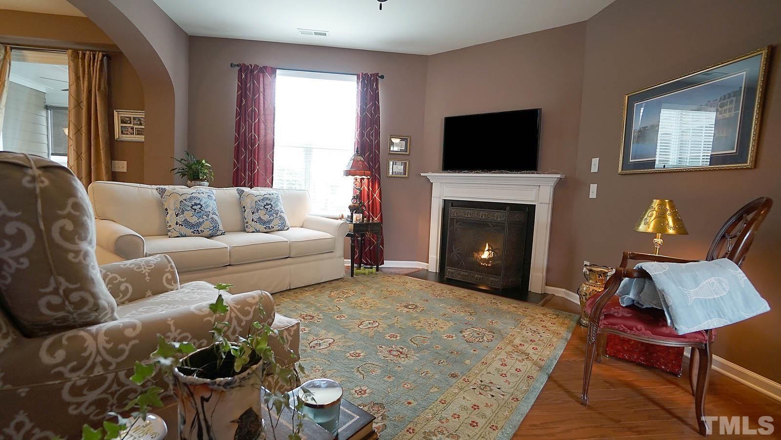 10115 Barnhart Way Raleigh, NC 27617 - Photo 6 of 60 a living room with furniture and a fireplace