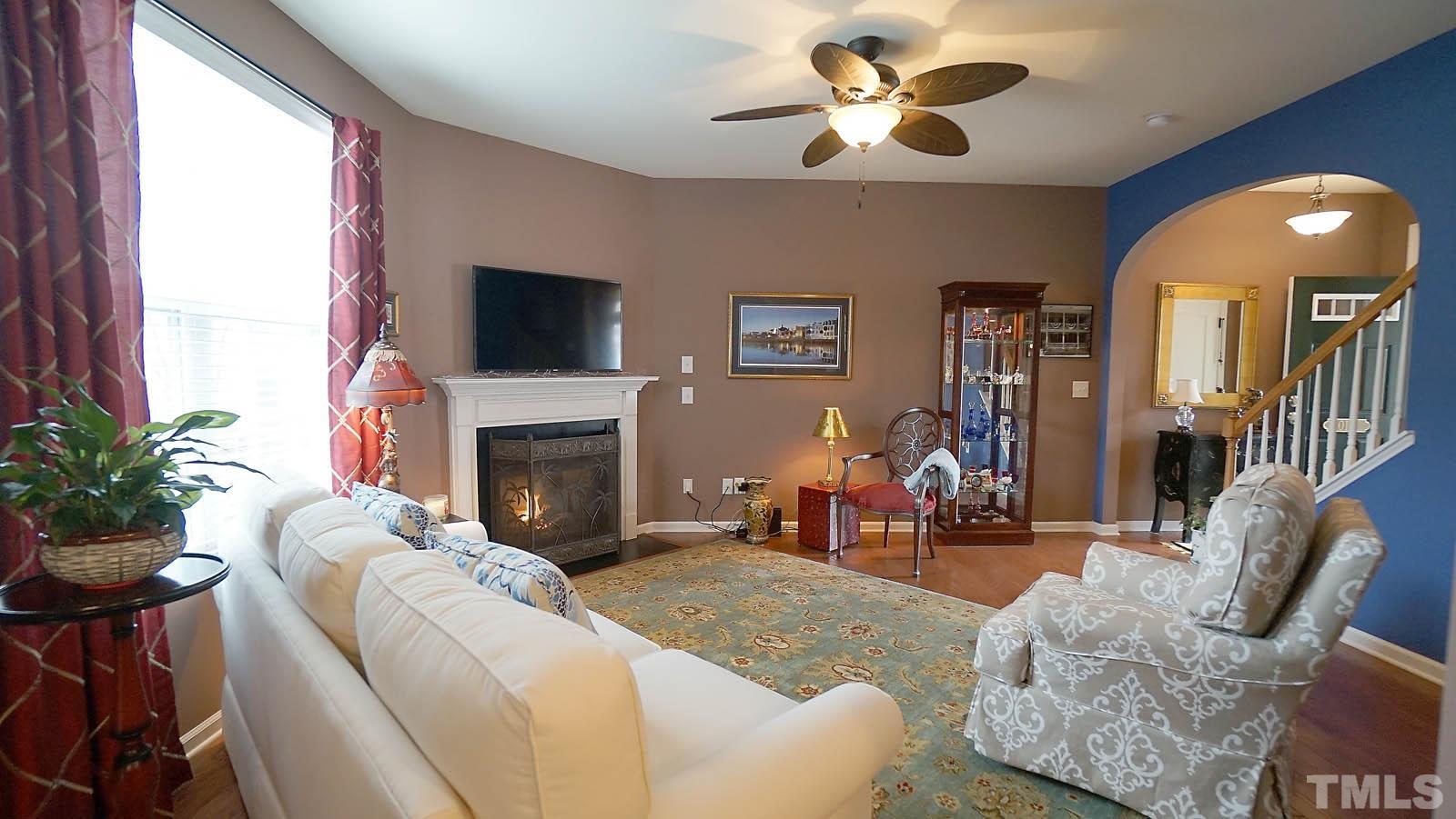 10115 Barnhart Way Raleigh, NC 27617 - Photo 7 of 60 a living room with furniture a fireplace and a flat screen tv