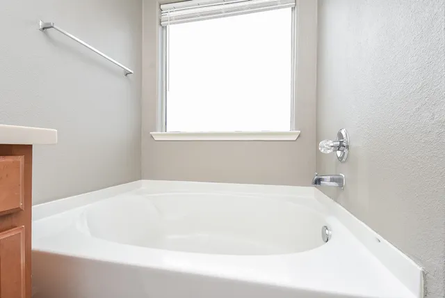 a white bath tub sitting next to a window