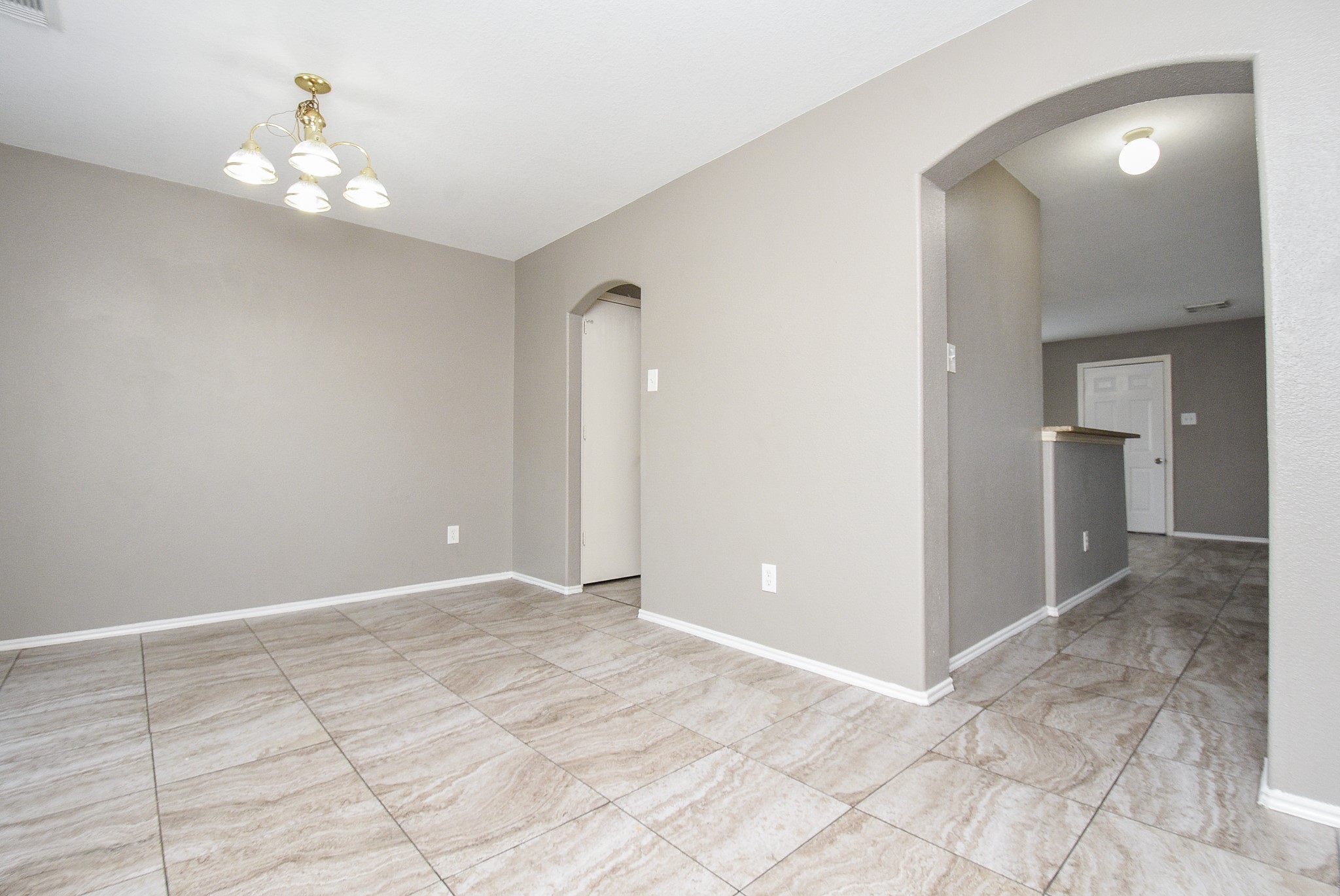 642 Kiley Drive Houston, TX 77073 - Photo 3 of 24 an empty room with kitchen and chandelier fan