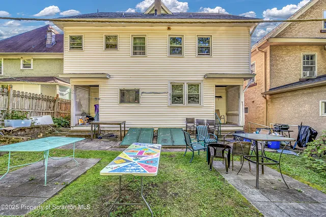 a view of a house with backyard and sitting area