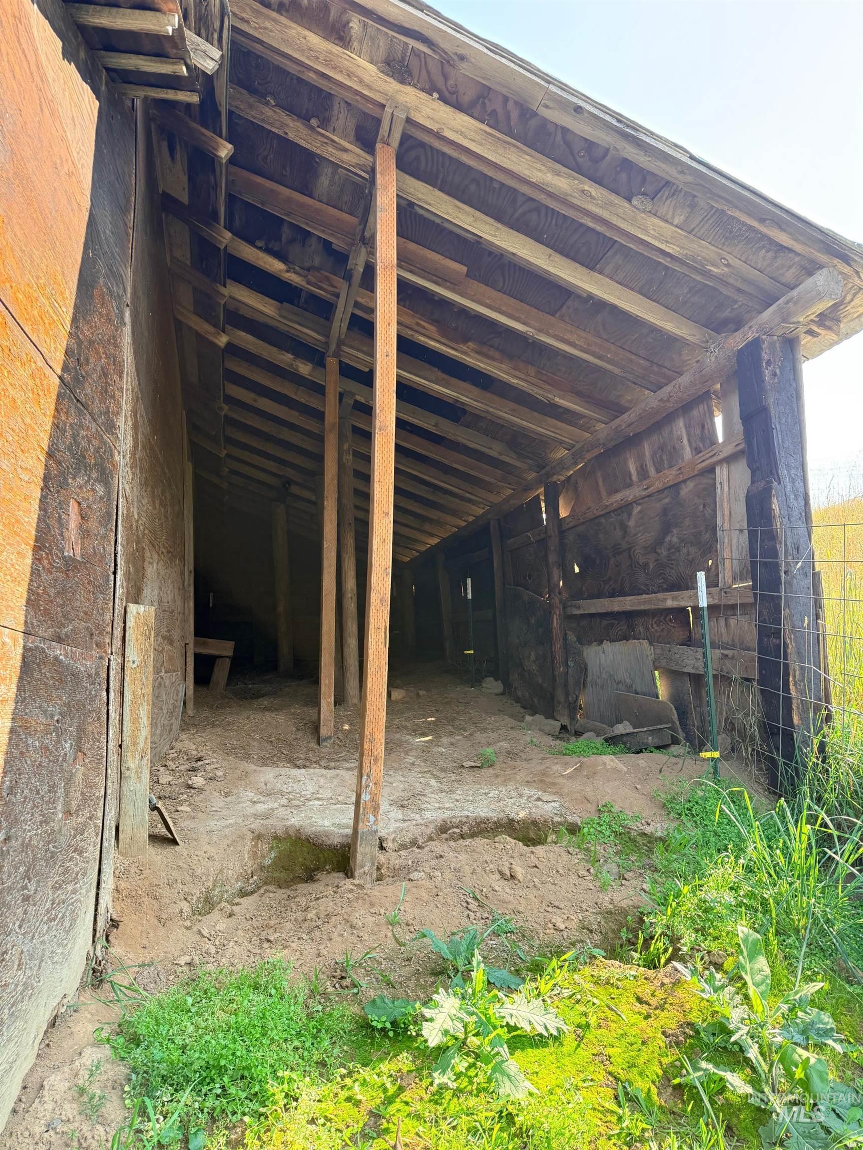126 Aitken Road Weippe, ID 83553 - Photo 27 of 39 Open-air structure featuring exposed wood framing, a shed-style roof, and a partial dirt floor