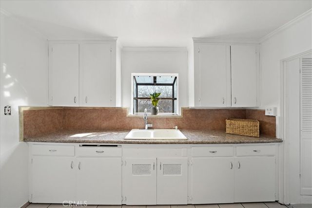 a kitchen with granite countertop a sink a stove and cabinets