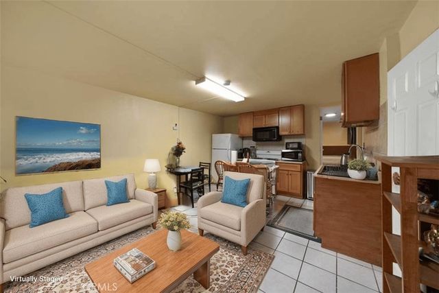 a kitchen with stainless steel appliances granite countertop a stove top oven a sink dishwasher a dining table and chairs with wooden floor