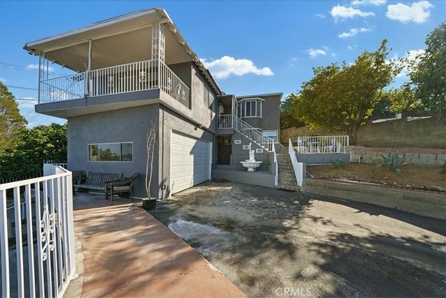 a view of a house with backyard and sitting area