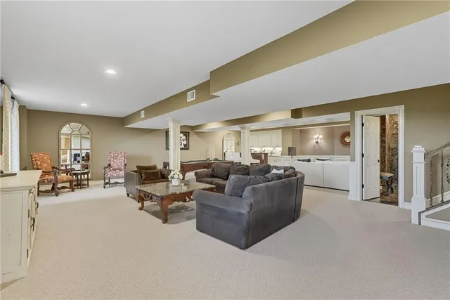 a living room with furniture and a refrigerator