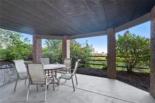 a view of a patio with a table chairs and a backyard