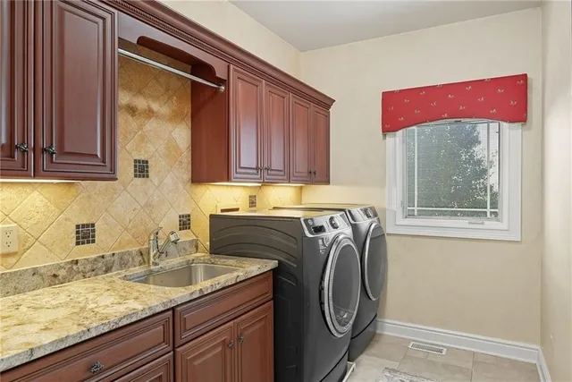 a utility room with granite countertop a sink a washer and dryer