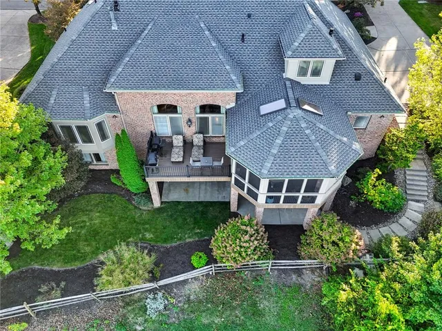 an aerial view of a house with garden space and a bench