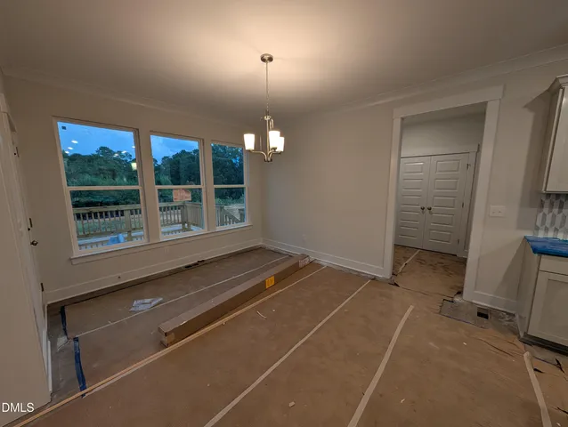 a view of an empty room with fireplace and a window