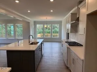 a kitchen with granite countertop a sink stove and cabinets