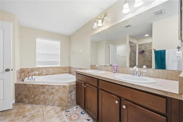 a bathroom with a tub sink and mirror