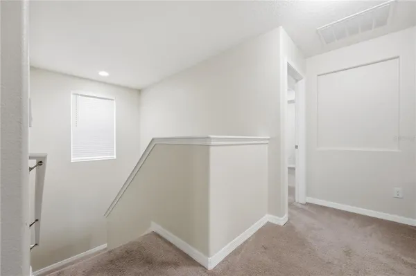 a view of a hallway with wooden floor and entryway