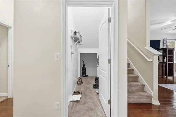 a view of a livingroom with wooden floor and stairs