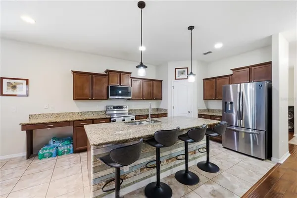 a kitchen with stainless steel appliances granite countertop a sink stove and refrigerator