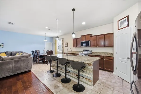 a view of kitchen with refrigerator stove dining table and chairs