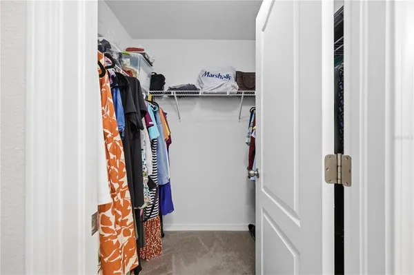 a view of walk in closet with clothes