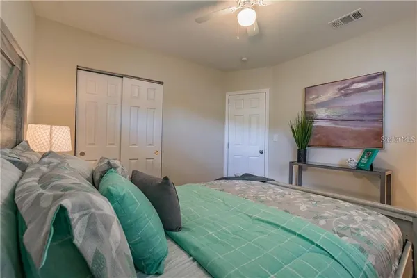 a bedroom with a bed and a painting on the wall