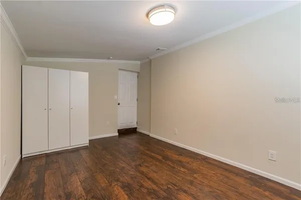 a view of an empty room with wooden floor