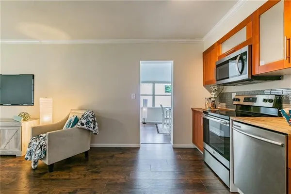 a living room with stainless steel appliances granite countertop furniture a fireplace and a flat screen tv
