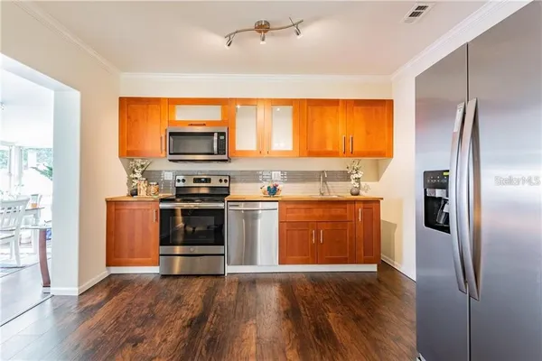 a kitchen with stainless steel appliances a refrigerator and a stove top oven
