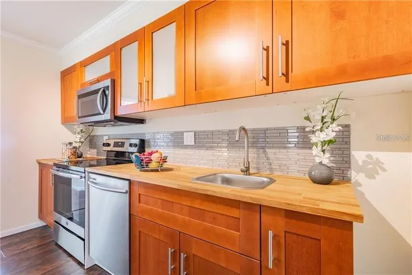 a kitchen with stainless steel appliances a sink a stove and cabinets