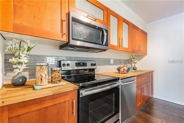 a kitchen with stainless steel appliances a stove a microwave a sink and cabinets
