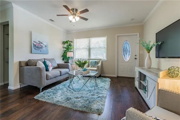 a living room with furniture a flat screen tv and a window