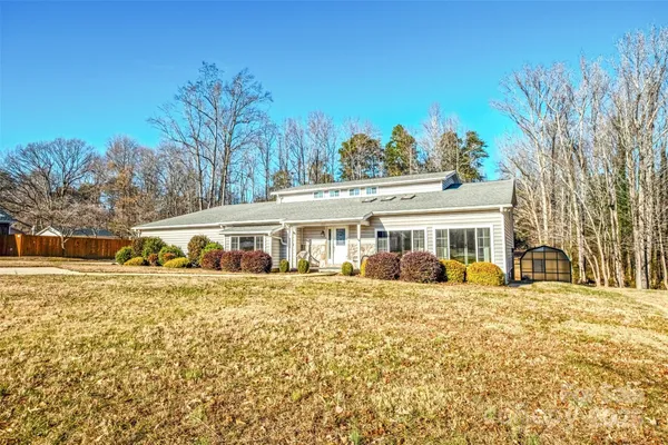 a front view of a house with a yard covered with trees