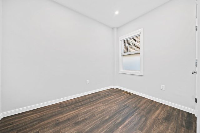 a view of a room with wooden floor and white walls