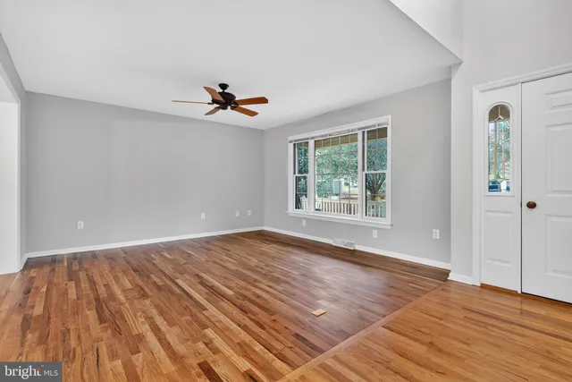 a view of an empty room with wooden floor